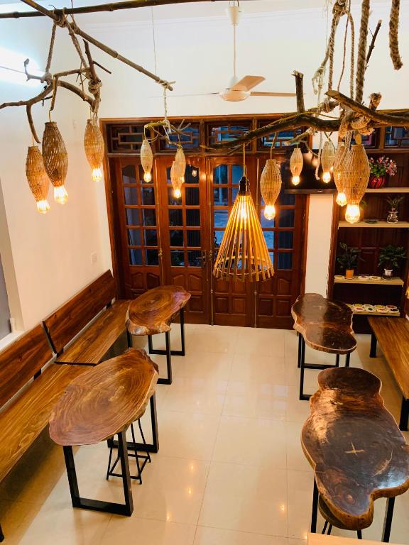 a room with chairs and lights and a bar at Be's Home & Tours in Ha Giang