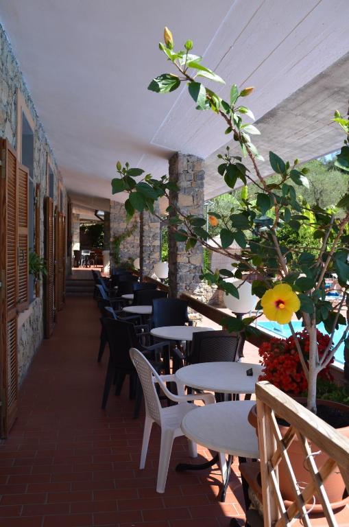 a patio with tables and chairs and a tree at Campeggio Gianna Golfo dei Poeti in Lerici