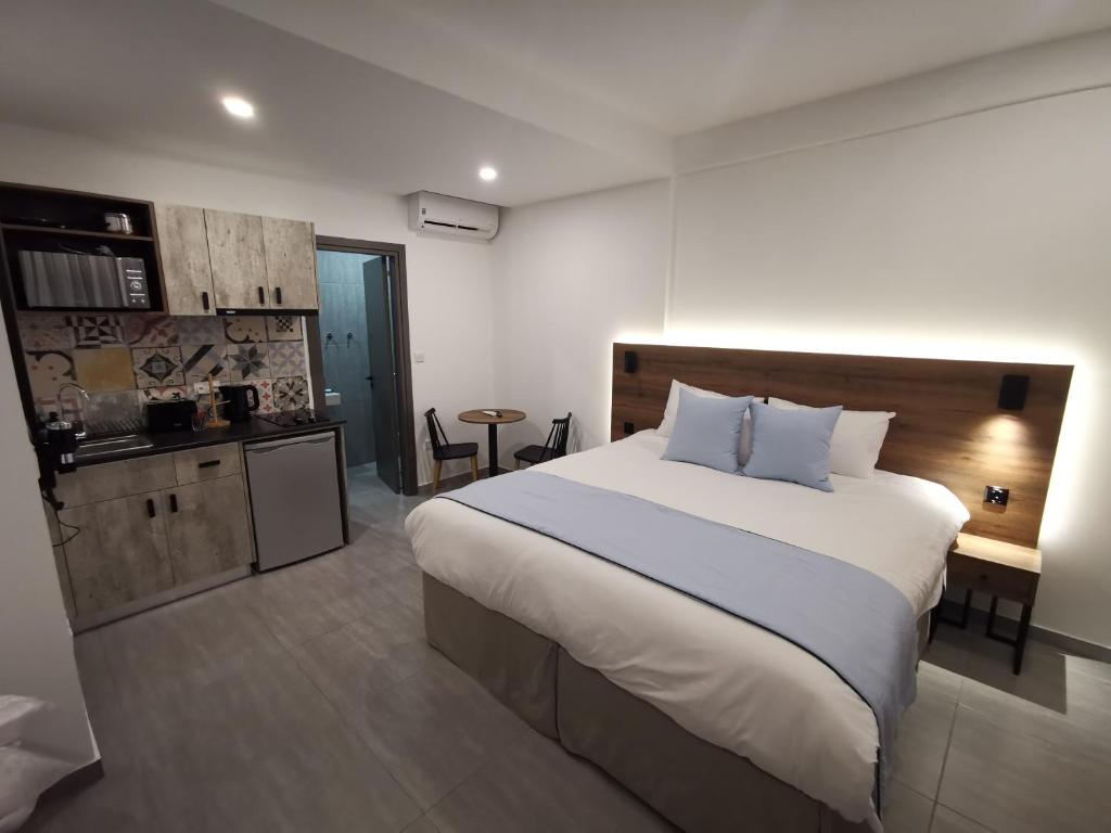 a bedroom with a large bed and a kitchen at Shalos Studios in Ayia Napa