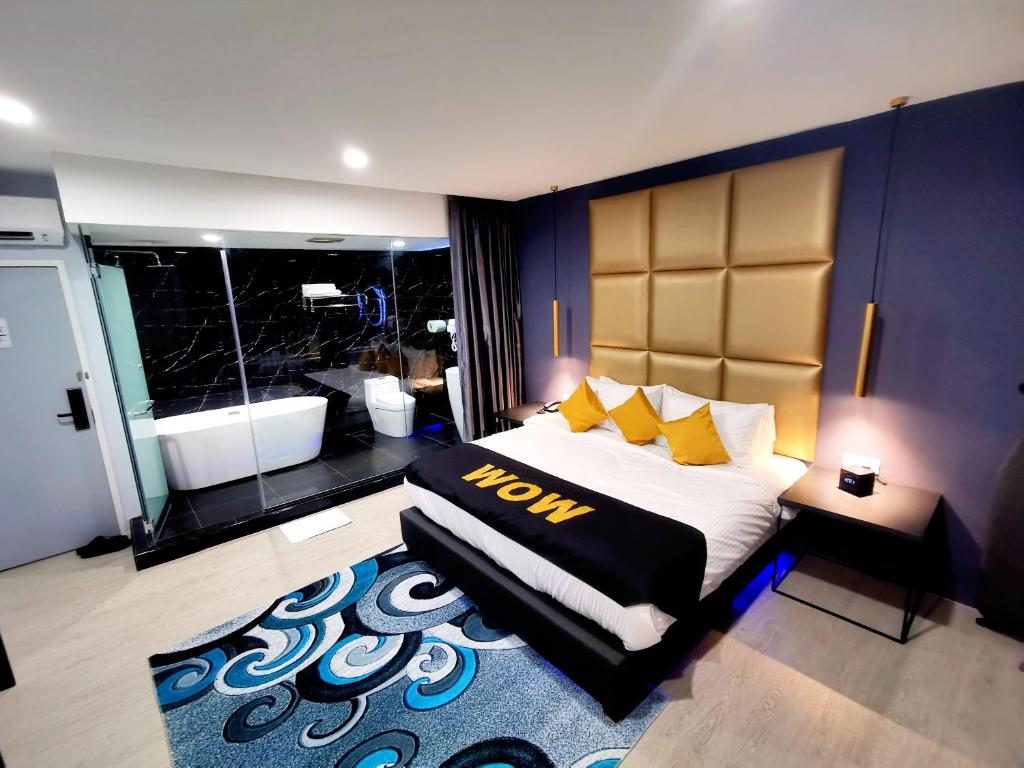 sypialnia z dużym łóżkiem z żółtymi poduszkami w obiekcie WOW Hotel Penang w mieście George Town