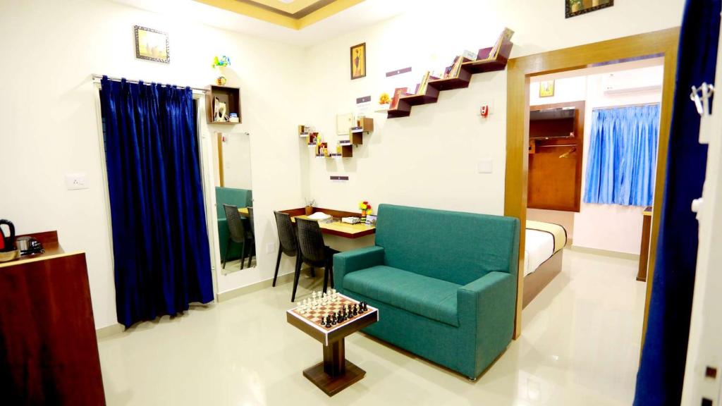 a living room with a blue chair and a desk at Base9 Cochin Airport Hotel in Nedumbassery