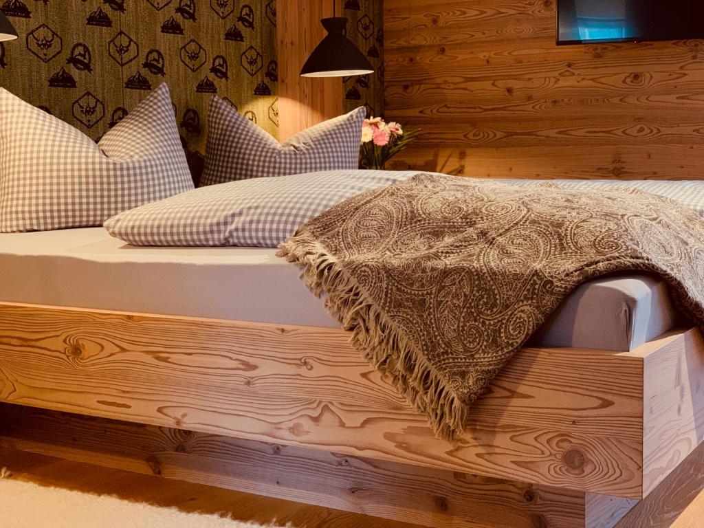 a wooden bed with a blanket on top of it at Bergleben in Krün