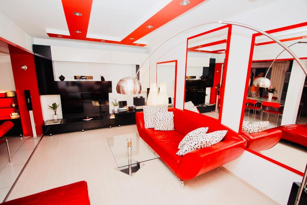 クルジュ・ナポカにあるRed Nest Homestayのリビングルーム(赤いソファ、テーブル付)