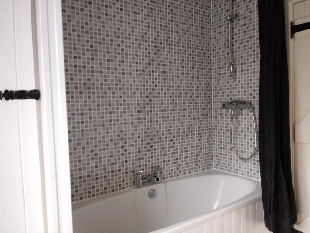 eine weiße Badewanne im Bad mit Dusche in der Unterkunft The Boat Inn in Monmouth
