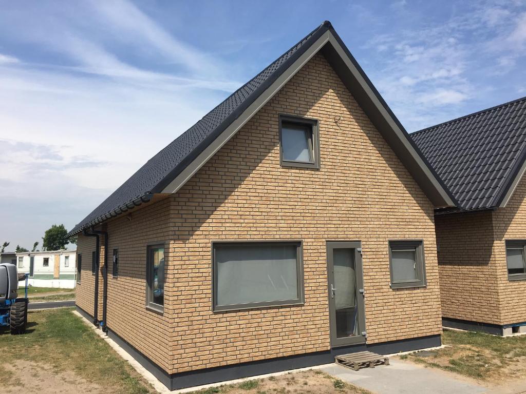 una casa con techo negro en Camping Thalassa Belgische Kust Vakantiehuis en Bredene