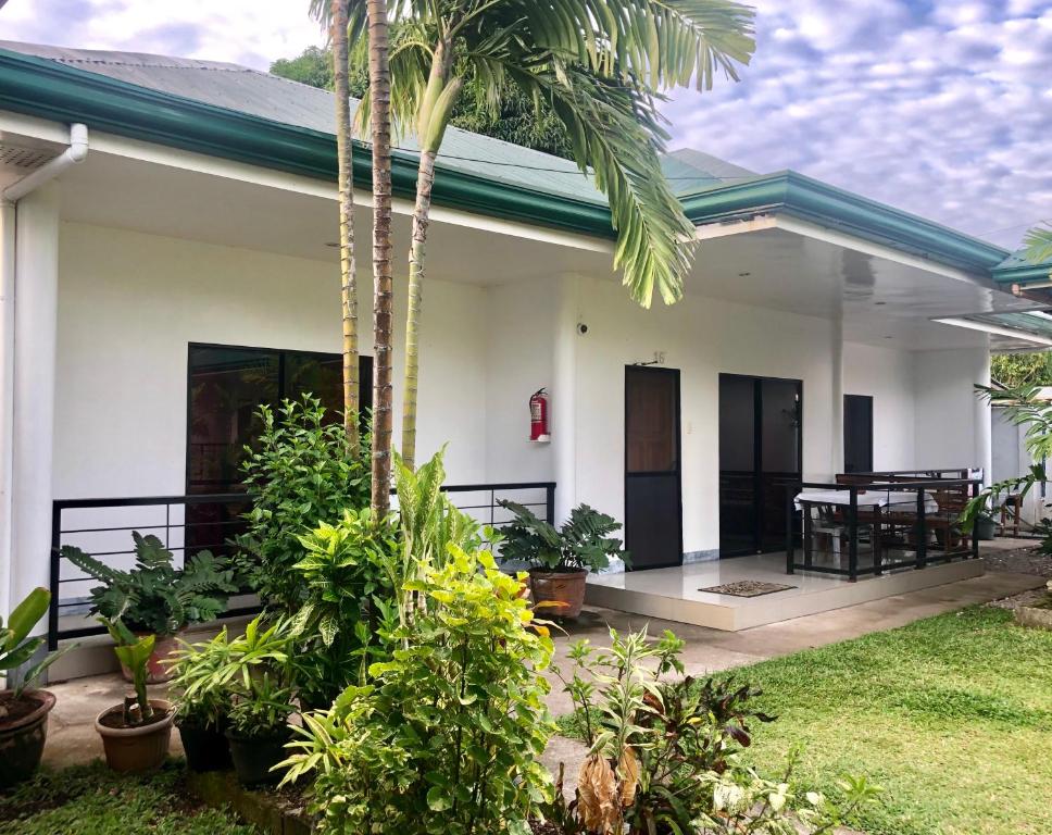 ein Haus mit einer Palme davor in der Unterkunft Paguia’s Cottages in Mambajao