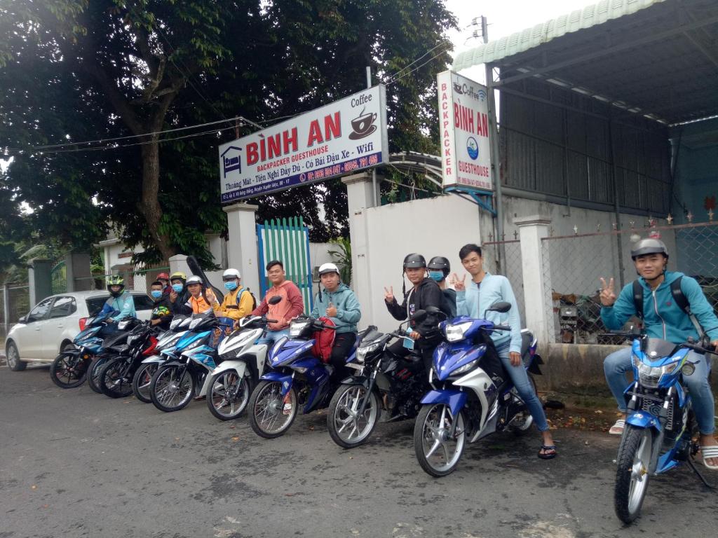un grupo de personas en motocicletas estacionado frente a un edificio en Binh An Backpacker Guesthouse, en Ho Coc