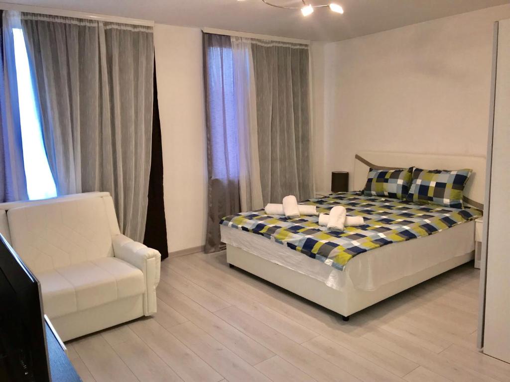 ein Schlafzimmer mit einem Bett und einem Stuhl in der Unterkunft Colors Apartment Sarajevo in Sarajevo