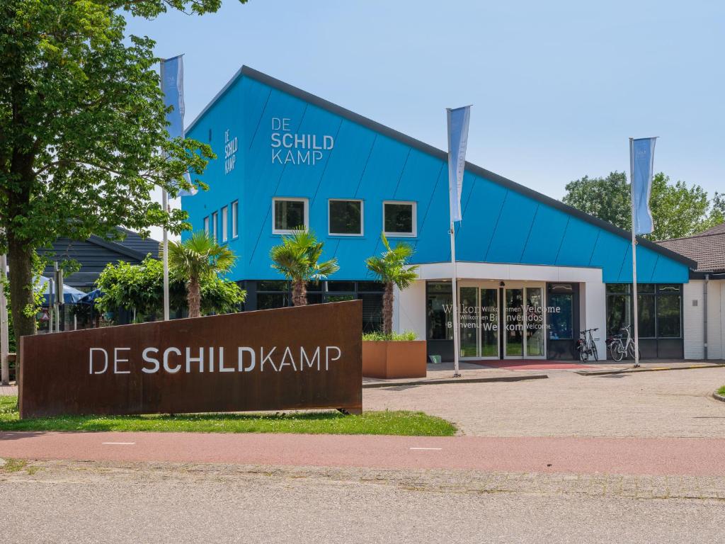 un edificio azul con un cartel delante en Hotel De Schildkamp, en Asperen