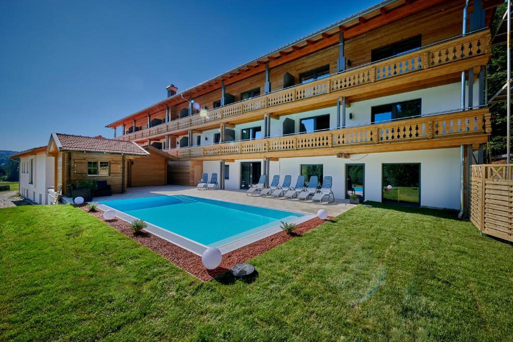 - une vue sur l'extérieur d'une maison avec une piscine dans l'établissement Landhotel Moorhof, à Neuschönau