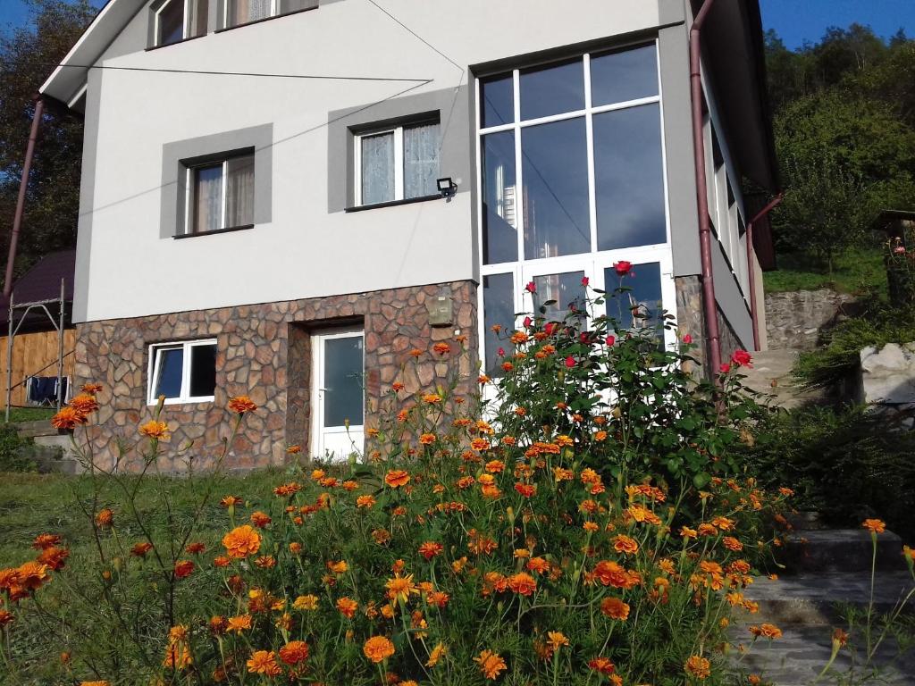 ein Haus mit Blumen davor in der Unterkunft Casa din prund Ocolis in Ocoliş