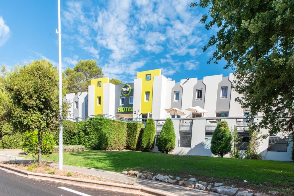 un edificio bianco e giallo su una strada di B&B HOTEL Antibes Sophia Le Relais a Biot