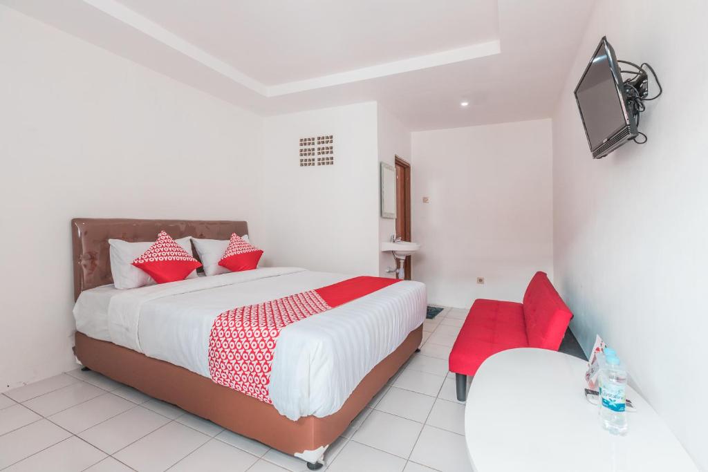 a bedroom with a large bed with red pillows at OYO 947 Angel Home Stay Syariah Near Atrium Pondok Gede, Museum Monumen Pancasila, Taman Mini in Jakarta