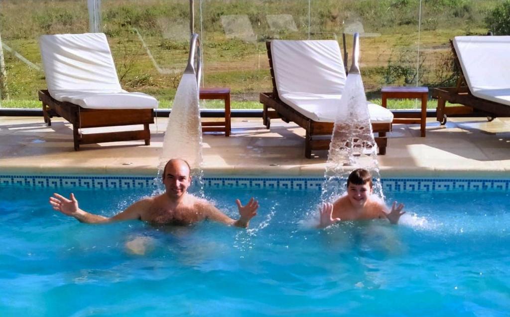 Dos hombres están jugando en una piscina en Iguape Aparts & Spa en Colón