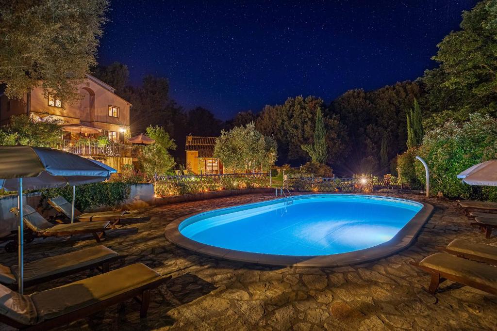 a swimming pool in a yard at night at Pian Delle More in Sassetta