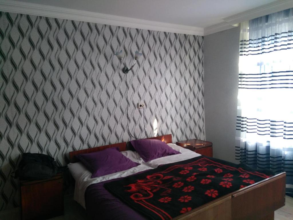 Schlafzimmer mit einem Bett mit gemusterter Wand in der Unterkunft 9 Plus - Orbeli in Orbeli