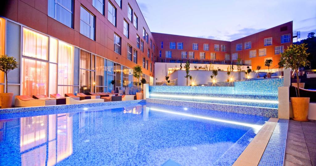 ein Hotelpool mit Stühlen und ein Gebäude in der Unterkunft Hotel Terme Sveti Martin in Sveti Martin na Muri