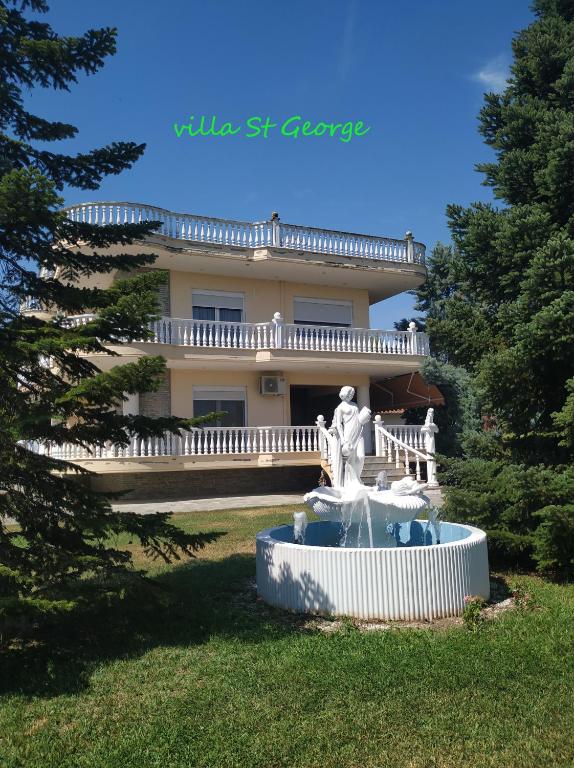 a statue in front of a building with a fountain at Villa St.George in Katerini