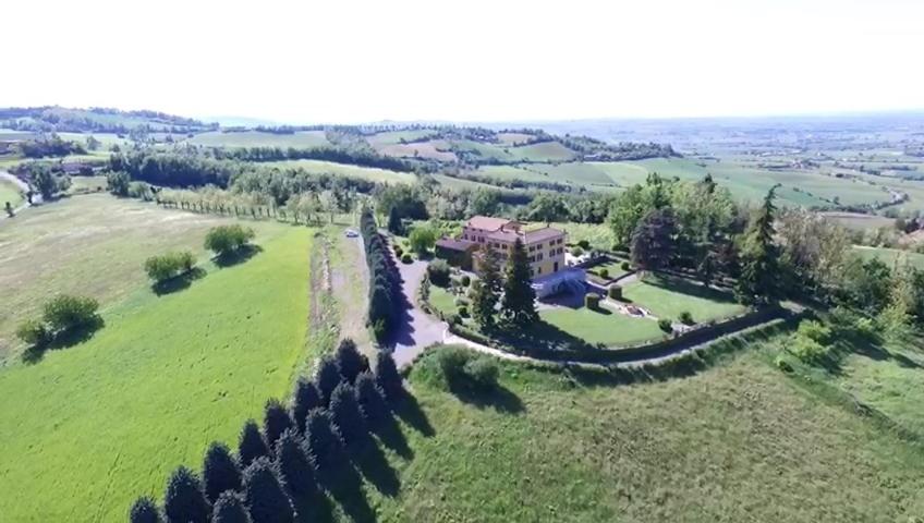 an aerial view of a house in a green field at Villa La Palazzina in Agazzano