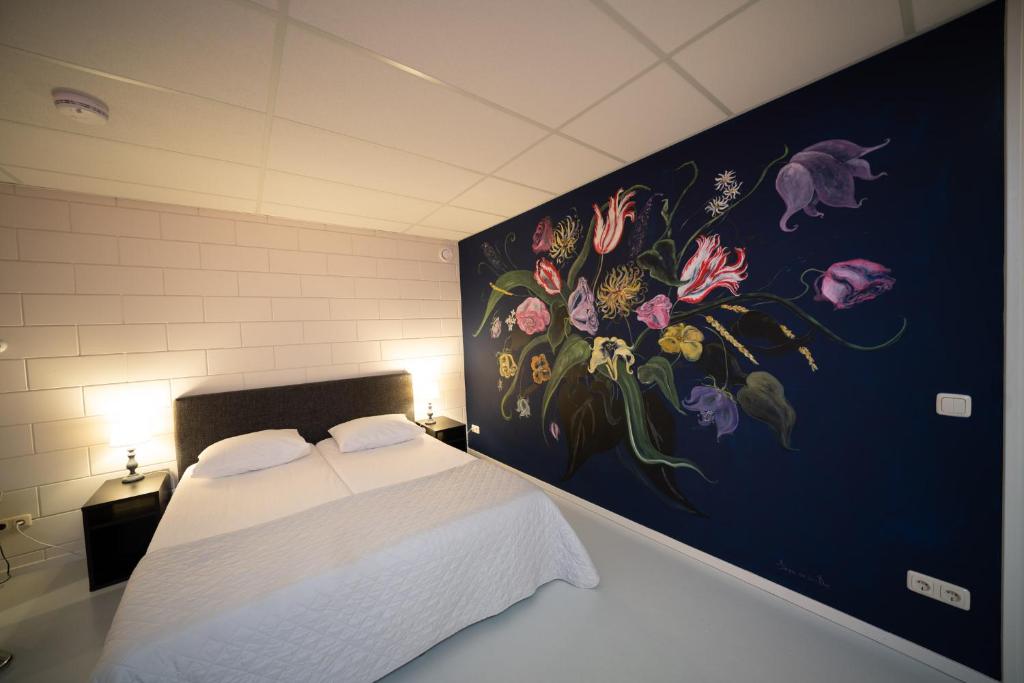 een slaapkamer met een bloemschilderij aan de muur bij Beach Suites Lemmer in Lemmer