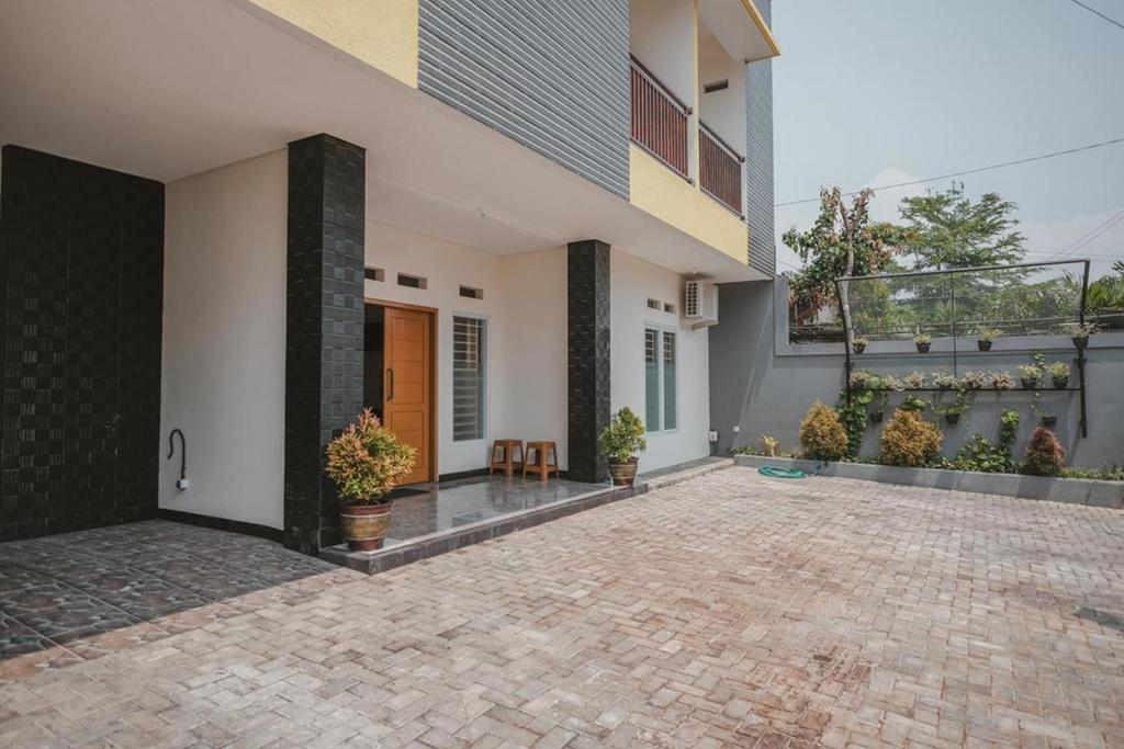 a courtyard of a house with a brick driveway at RedDoorz Syariah near Pahoman Stadium Lampung in Bandar Lampung