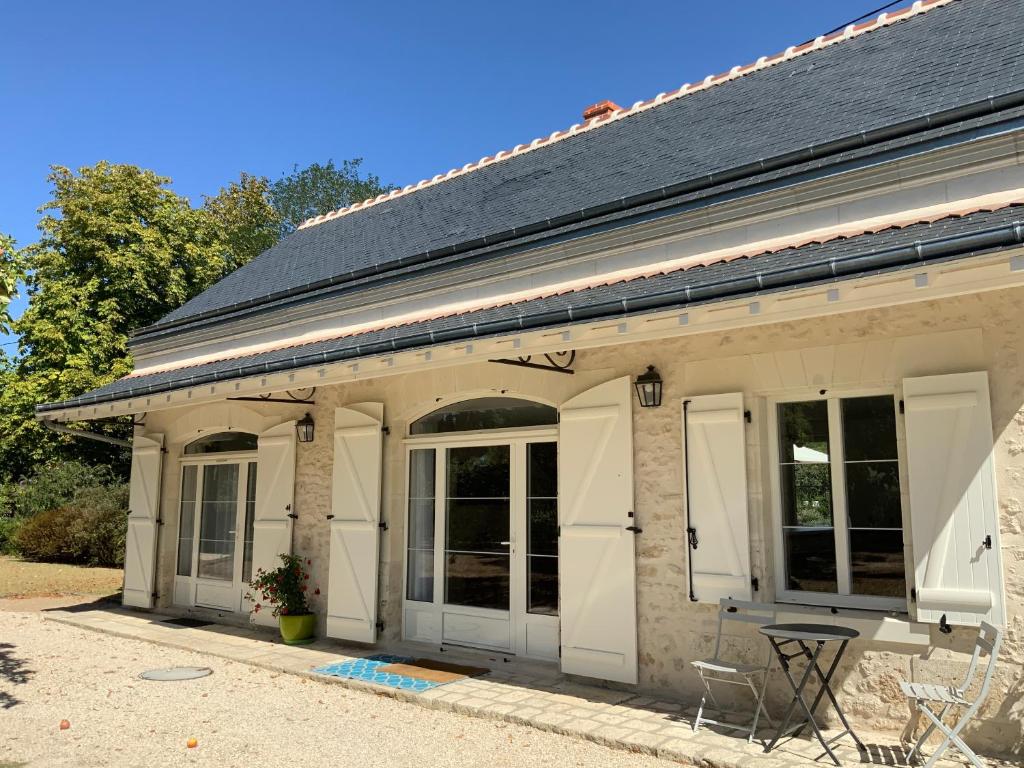 ein Haus mit weißen Türen sowie einem Tisch und Stühlen in der Unterkunft Le Gite du Chemin Vert in Pontlevoy