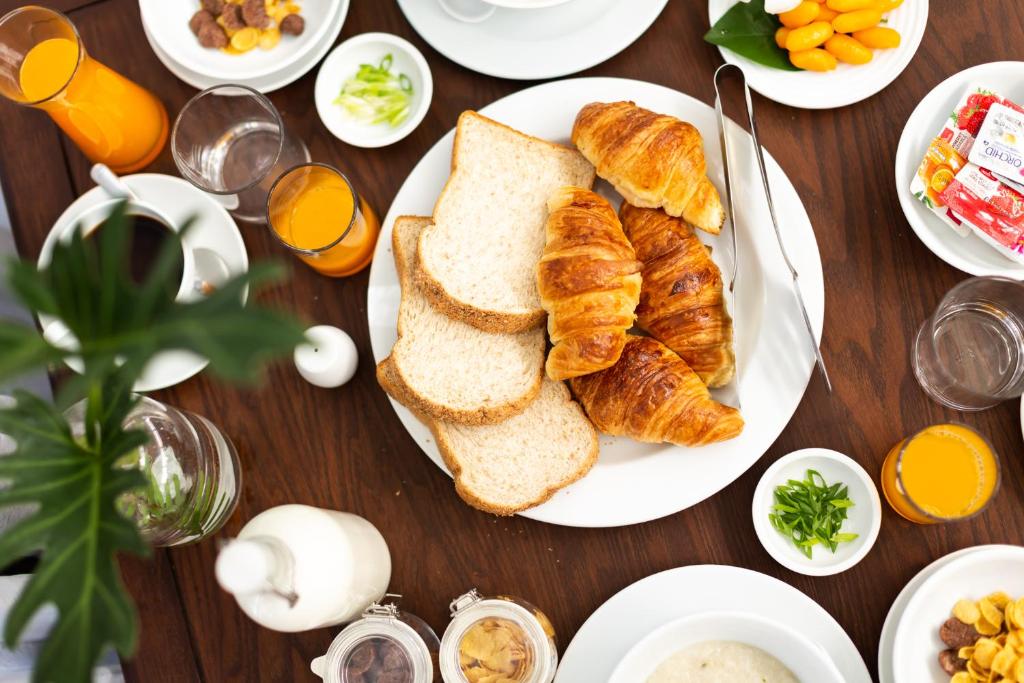 A breakfast spread centered on sliced bread and croissants.