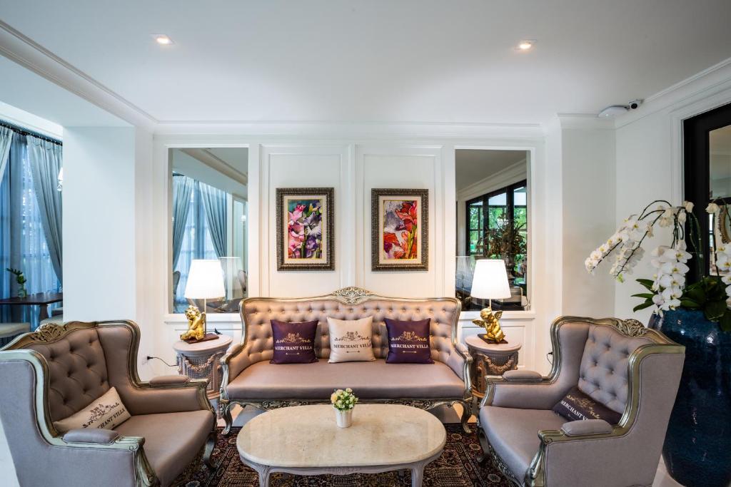 A formal living room with a sofa, two armchairs and a central coffee table.