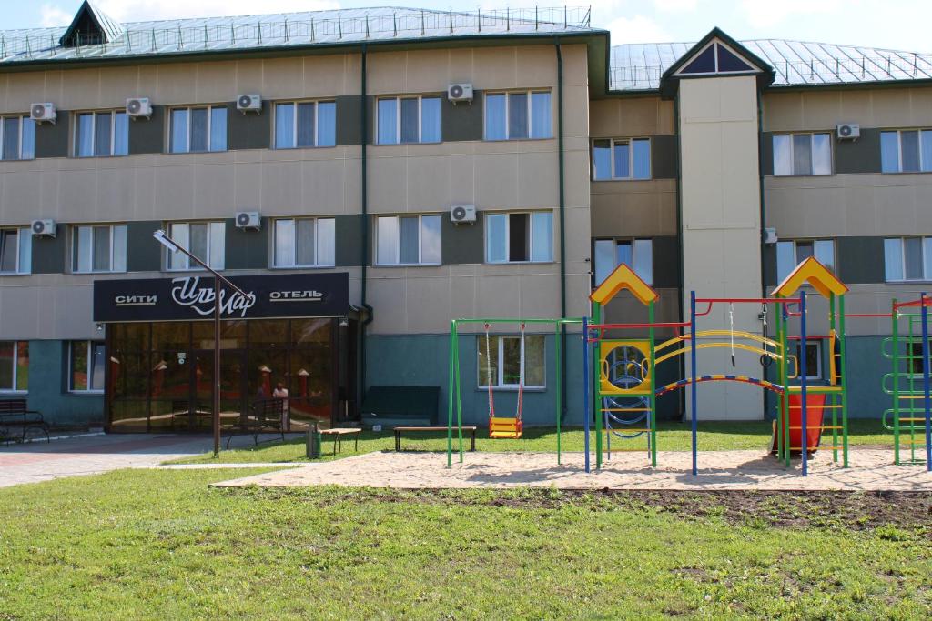 a building with a playground in front of a building at Ilmar City Hotel in Kazan