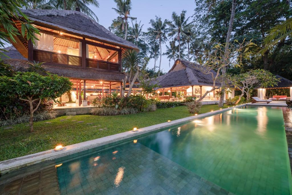 
a house with a pool and a pool table in front of it at Villa Pantulan Bali in Ubud
