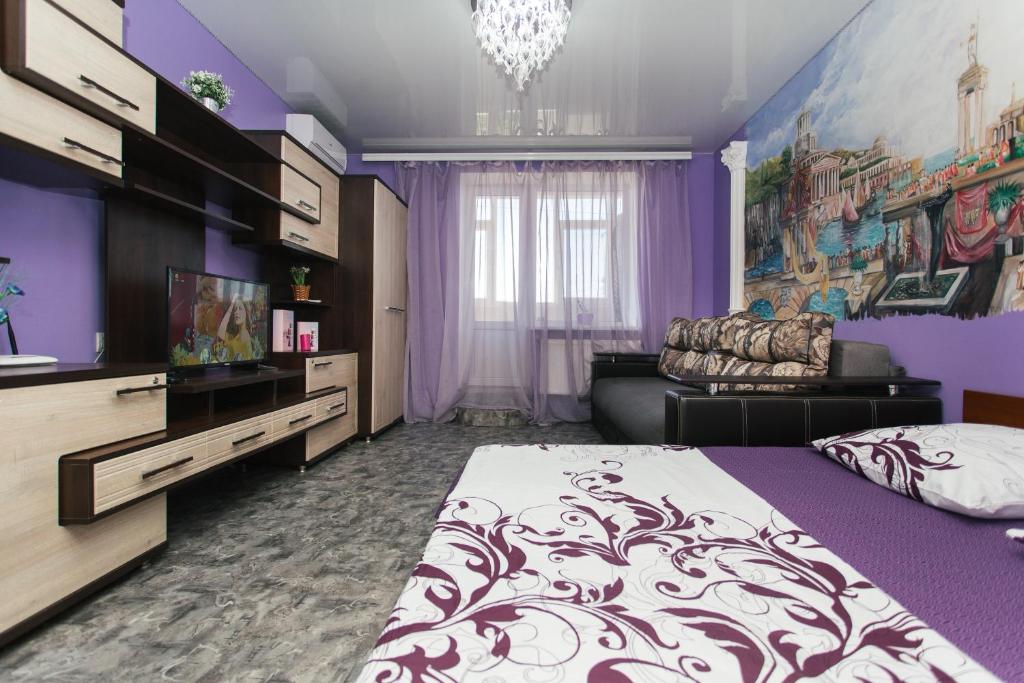 スームィにあるVIP Apartmens Faraon On Illinskaya 1 floorの紫色のベッドルーム(ベッド1台、ソファ付)