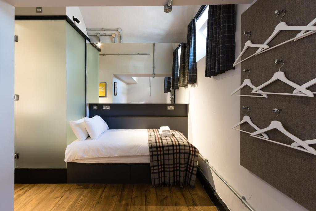 a bedroom with a bed and hangers on the wall at CoDE Pod – The CoURT - Edinburgh in Edinburgh