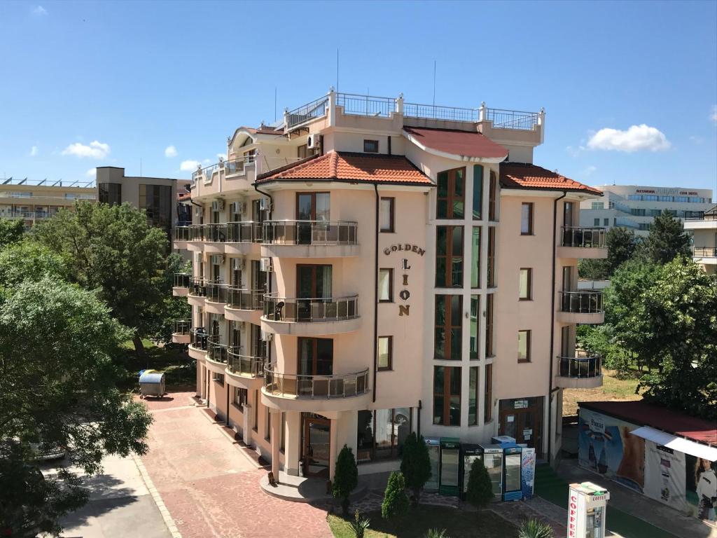 ein hohes weißes Gebäude mit rotem Dach in der Unterkunft Hotel Golden Lion in Primorsko