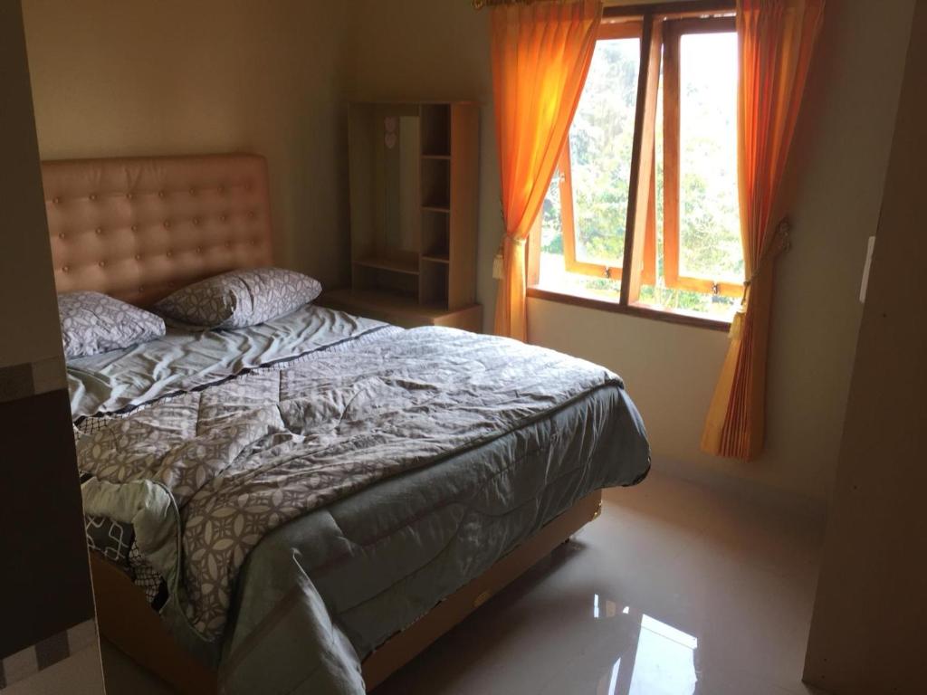 a bedroom with a bed and a window at Wildan Homestay in Mangun