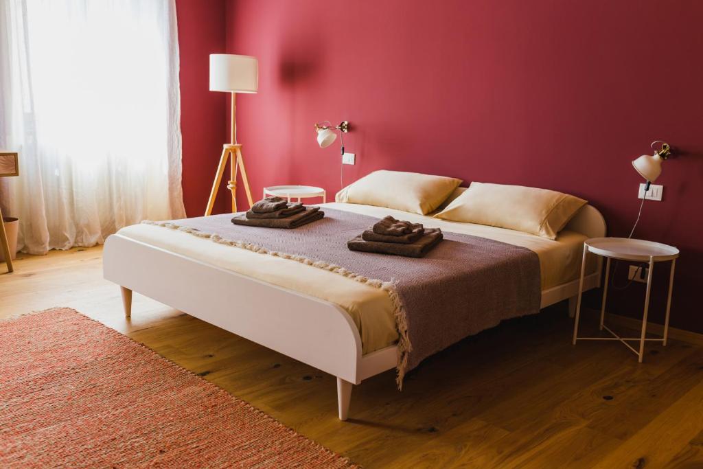 1 dormitorio con 1 cama grande y pared roja en B&B Adelaide, en Trieste