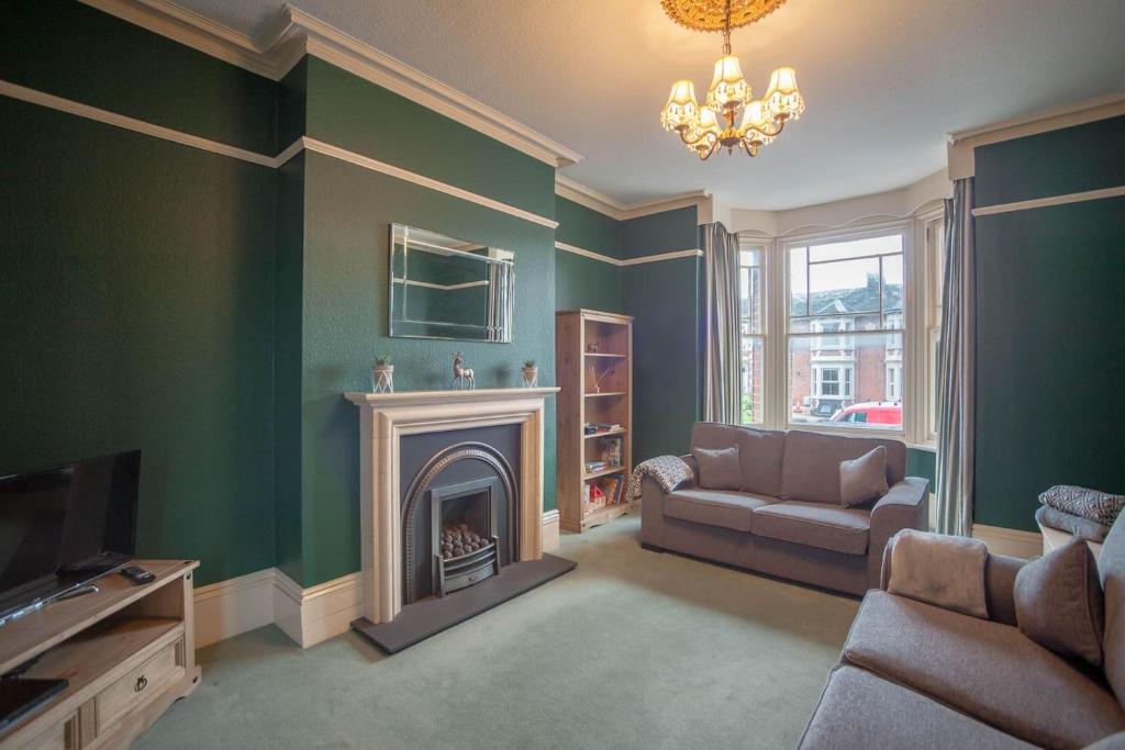 a living room with a couch and a fireplace at Falcon House By RentMyHouse in Hereford