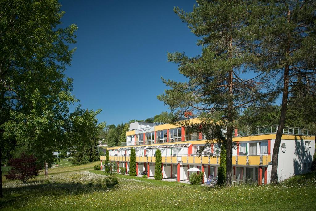 een gebouw met veel ramen en bomen bij Das Allgäu in Maierhöfen