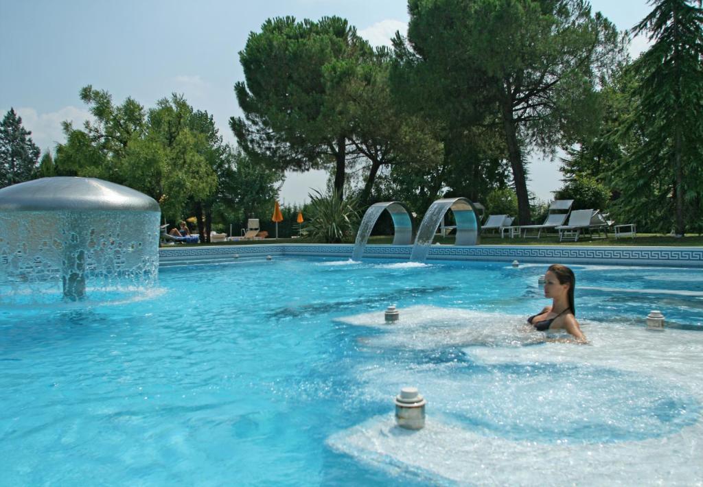 una mujer está nadando en una piscina en Hotel Terme Neroniane en Montegrotto Terme