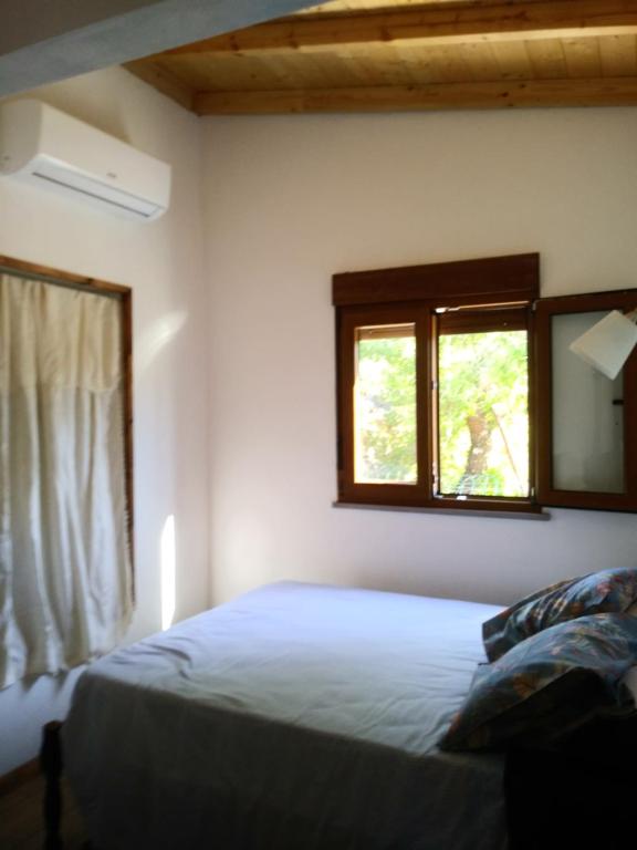 a bedroom with a bed and two windows at Casinha do Sul in Faro
