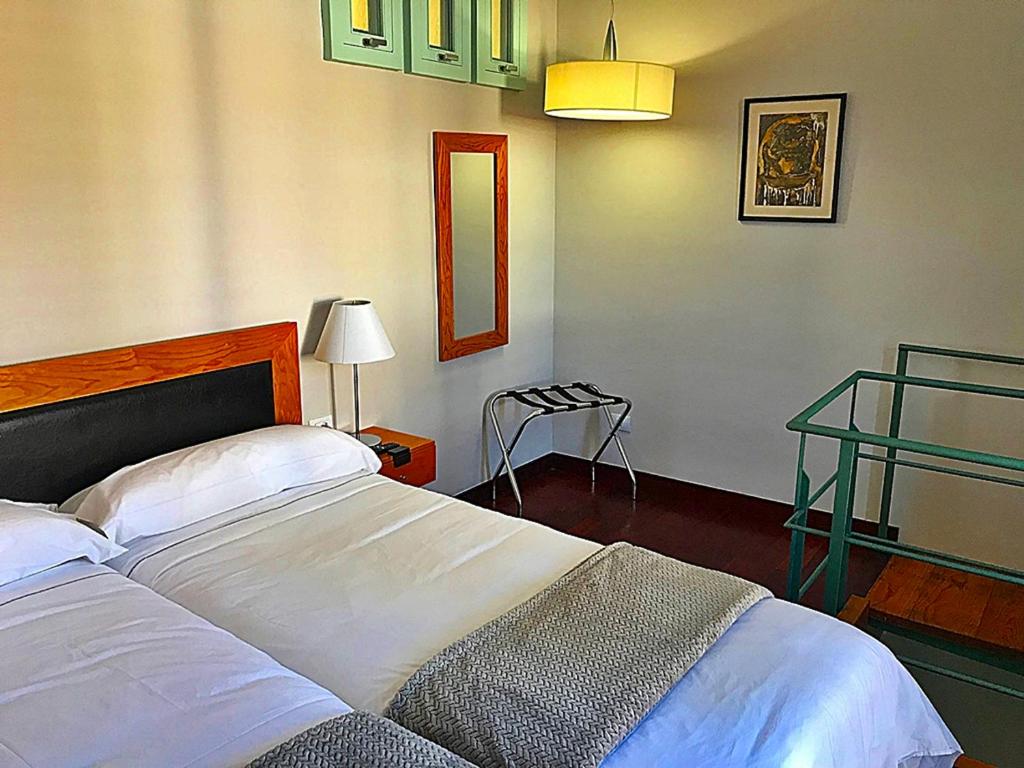 a bedroom with a bed and a lamp and a table at Hotel Rural Triana in Vallehermoso