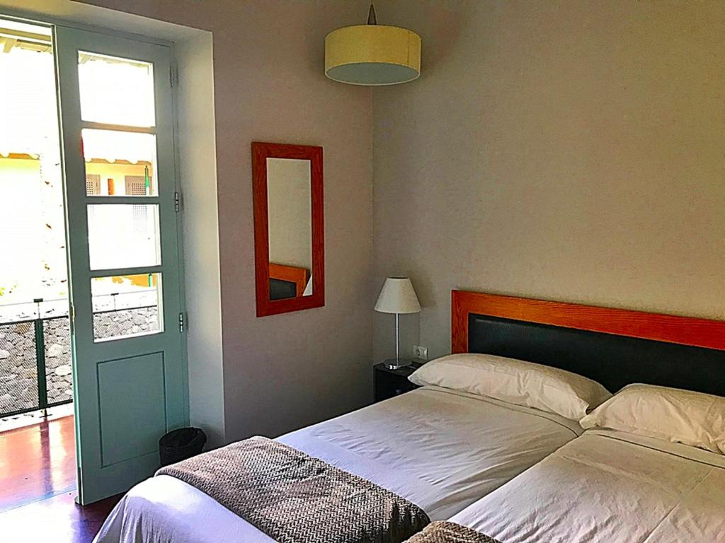 a bedroom with two beds and a window and a door at Hotel Rural Triana in Vallehermoso