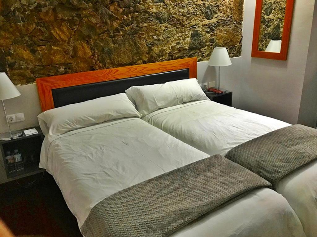 a bedroom with two beds with white sheets at Hotel Rural Triana in Vallehermoso