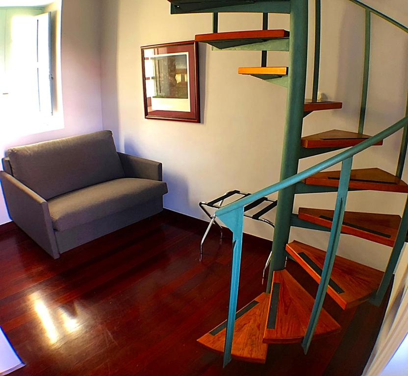 a living room with a spiral staircase and a couch at Hotel Rural Triana in Vallehermoso