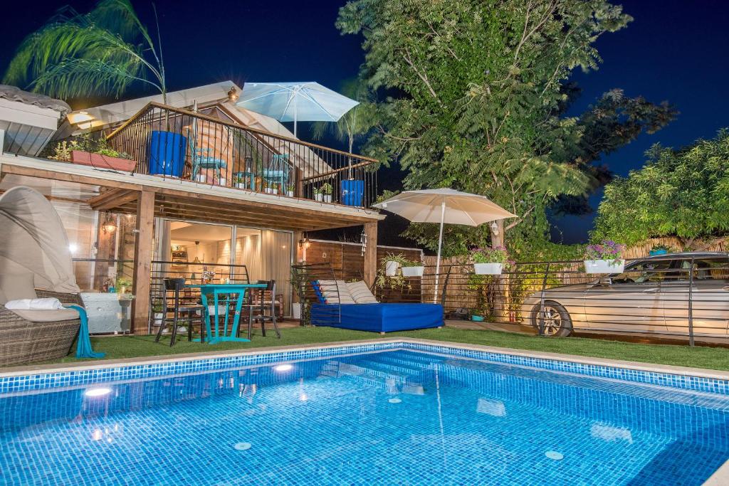 a house with a swimming pool in front of a house at בין שקד לתמר יסוד המעלה in Yesod Hamaala