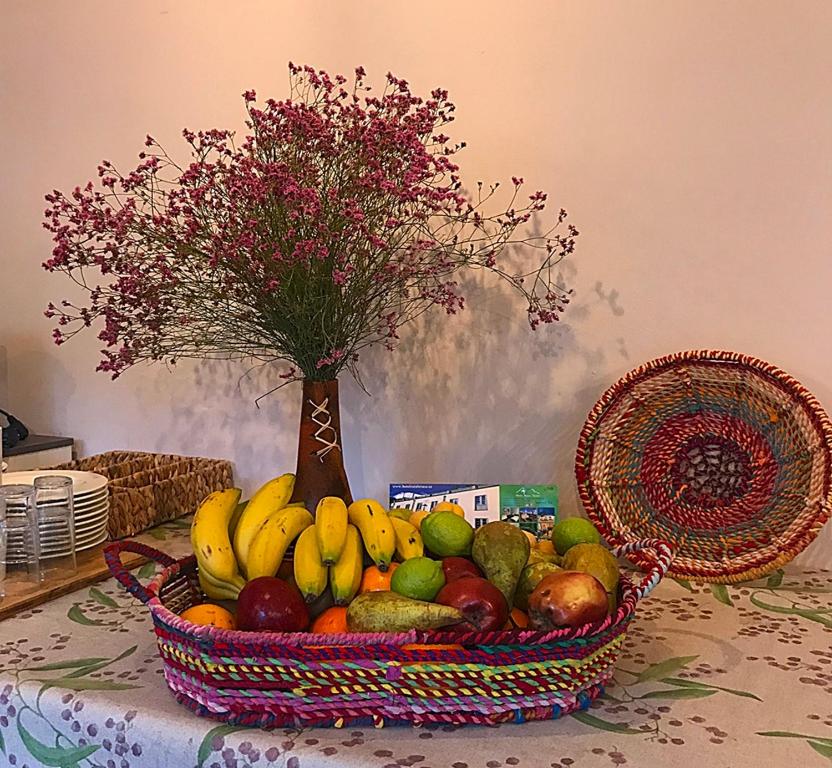 a basket of fruit on a table with a vase of flowers at Hotel Rural Triana in Vallehermoso
