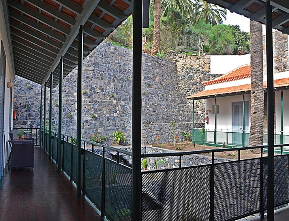 a balcony with a stone wall and a building at Hotel Rural Triana in Vallehermoso