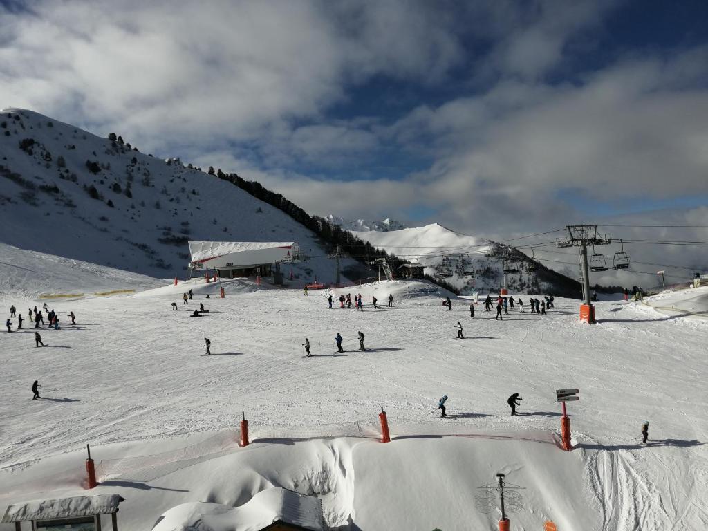 a group of people skiing down a snow covered slope at Plagne AIME 2000 Ski Apartments in Aime-La Plagne