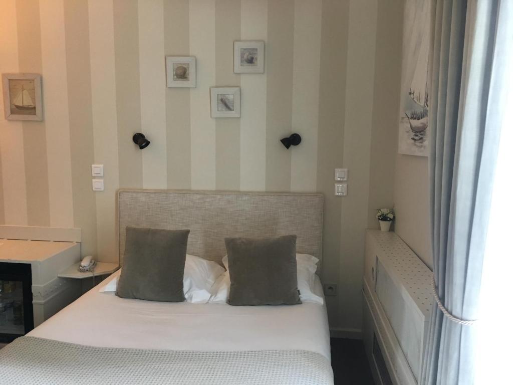 Uma cama ou camas num quarto em Hôtel du Parc