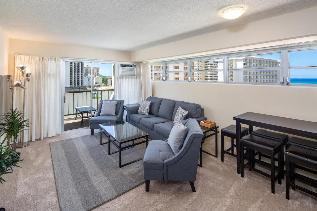 a living room with a couch and a piano at Ocean View from Lanais-2 Blocks to Waikiki Beach in Honolulu