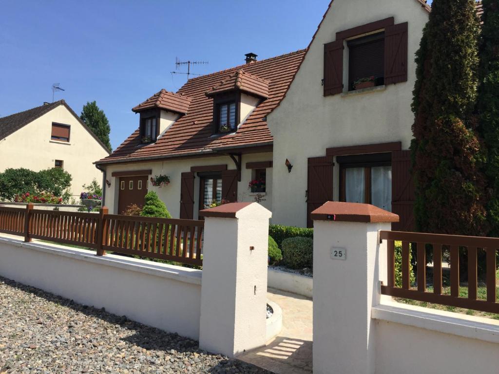 ein Haus mit einem Holzzaun davor in der Unterkunft CHEZ MARIA ET JOSE in Coucy-le-Château-Auffrique